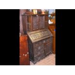 A carved oak bureau bookcase with fitted interior