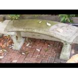 A curved concrete garden bench