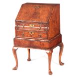 A QUEEN ANNE STYLE 19TH CENTURY BURR WALNUT BUREAU ON STAND with angled fall revealing a fitted