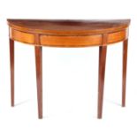 A GEORGE III MAHOGANY DEMI LUNE TEA TABLE with cross-banded edge above a panelled freize 100cm