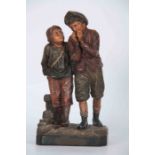 A 19TH CENTURY AUSTRIAN PAINTED TERRACOTTA FIGURE GROUP modeled as two standing boys labeled DU