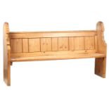 A 19TH CENTURY PINE CHURCH PEW with shaped ends joined by a plank seat and panelled back 174cm