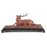 A LATE 19th CENTURY CARVED HARDWOOD SCULPTURE possibly Indian, of a stag being ravaged by a hound on