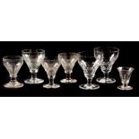 A COLLECTION OF SEVEN CUT GLASS WINE GLASSES / RUMMERS with faceted bodies 14.5cm high