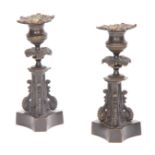 A PAIR OF REGENCY BRONZE CANDLESTICKS with leaf work decoration and tapering plinth with triform