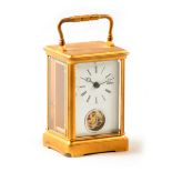 AN UNUSUAL GILT BRASS TIMEPIECE CARRIAGE CLOCK the corniche style case enclosing an enamel dial with