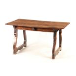 AN 18TH CENTURY SPANISH WALNUT TABLE with plank top above shaped end supports 145cm wide 80cm deep