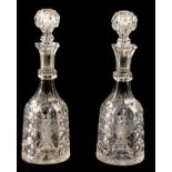 A PAIR OF 19TH CENTURY CUT GLASS WINE DECANTERS having etched grapes to the panelled sides 36cm high