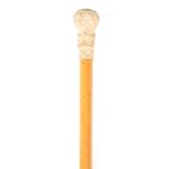AN EARLY 19TH CENTURY MALACCA CANE WALKING STICK WITH FINELY CARVED IVORY HANDLE AND CARVED MOTHER