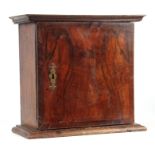 AN 18TH CENTURY OAK AND CROSSBANDED FIGURED WALNUT SPICE CABINET with hinged door enclosing a