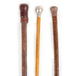 A COLLECTION OF THREE WALKING STICK comprising of a leather-bound walking stick/cosh with weighted