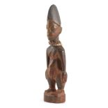 AN AFRICAN CARVED YORUBA MALE IBEJI with bead decoration 29.5cm high - From the ARNE IT