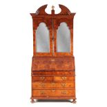 A WILLIAM AND MARY BURR WALNUT BUREAU BOOKCASE with broken arch pediment above shaped mirrored doors