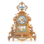 A LATE 19TH CENTURY FRENCH GILT SPELTER AND PORCELAIN PANELLED MANTEL CLOCK with urn finial and