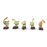 A SET OF FIVE CHINESE GREEN JADE GEESE STANDING ON SILVER INLAID HARDWOOD BASES all well carved