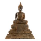 AN EARLY TIBETAN CAST BRONZE SEATED BUDDHA mounted on a stepped base 43cm high.