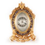 A LATE 19TH CENTURY FRENCH ORMOLU AND CHAMPLEVE ENAMEL STRUT STYLE MANTEL CLOCK the oval case with