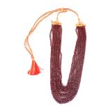 A GRADUATED RUBY BEAD EIGHT-ROW NECKLACE the faceted beads on a woven-thread sliding knot clasp, the