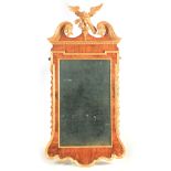 A GEORGE II WALNUT AND PARCEL-GILT MIRROR the original bevelled mirror plate within a shaped