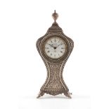 AN EARLY 20TH CENTURY SILVER SWIZA ALARM CLOCK with ornate embossed balloon-shaped body and urn