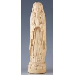 A 19TH CENTURY IVORY FIGURE OF THE VIRGIN MARY stood on an entwined serpent 28cm high.