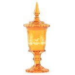 A 19TH CENTURY BOHEMIAN AMBER GLASS VASE AND COVER the faceted top with a tapered finial on matching