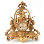 A LATE 19TH CENTURY FRENCH GILT METAL FIGURAL MANTEL CLOCK surmounted by two cherubs above a 3.5"