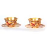 A PAIR OF SIGNED ROYAL WORCESTER LARGE TEA CUPS AND SAUCERS each richly gilt with painted all-