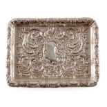 A GEORGE V ROCOCO STYLE SILVER TRAY of rectangular shape with pressed decoration, hallmarked