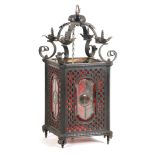 A VICTORIAN WROUGHT IRON AND PRESSED METAL HANGING HALL LANTERN with scrolled leaf work top above