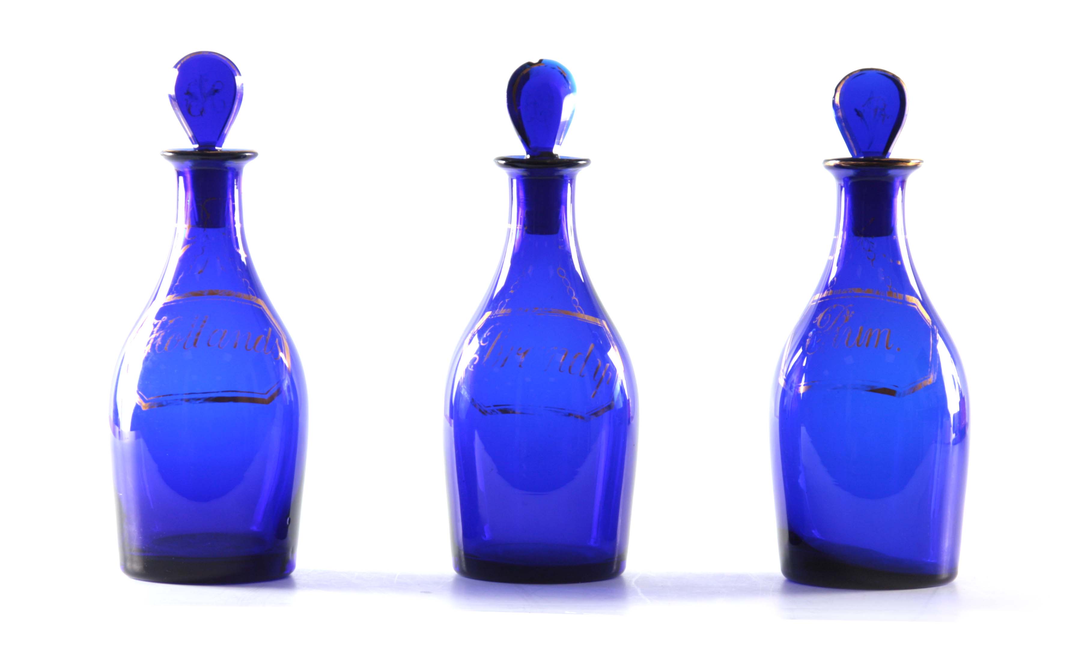 A SET OF THREE EARLY 19TH CENTURY BRISTOL BLUE GLASS DECANTERS for Rum, Brandy and Hollands with