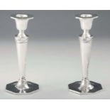 A PAIR OF GEORGE V ADAM STYLE SILVER CANDLESTICKS of octagonal shape with tapering stems decorated