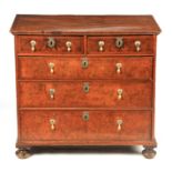 A WILLIAM AND MARY FIGURED WALNUT CHEST OF DRAWERS OF SMALL SIZE having a cross-banded quarter