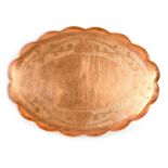 AN ARTS AND CRAFTS COPPER TRAY with raised scalloped border and pressed design 58cm wide
