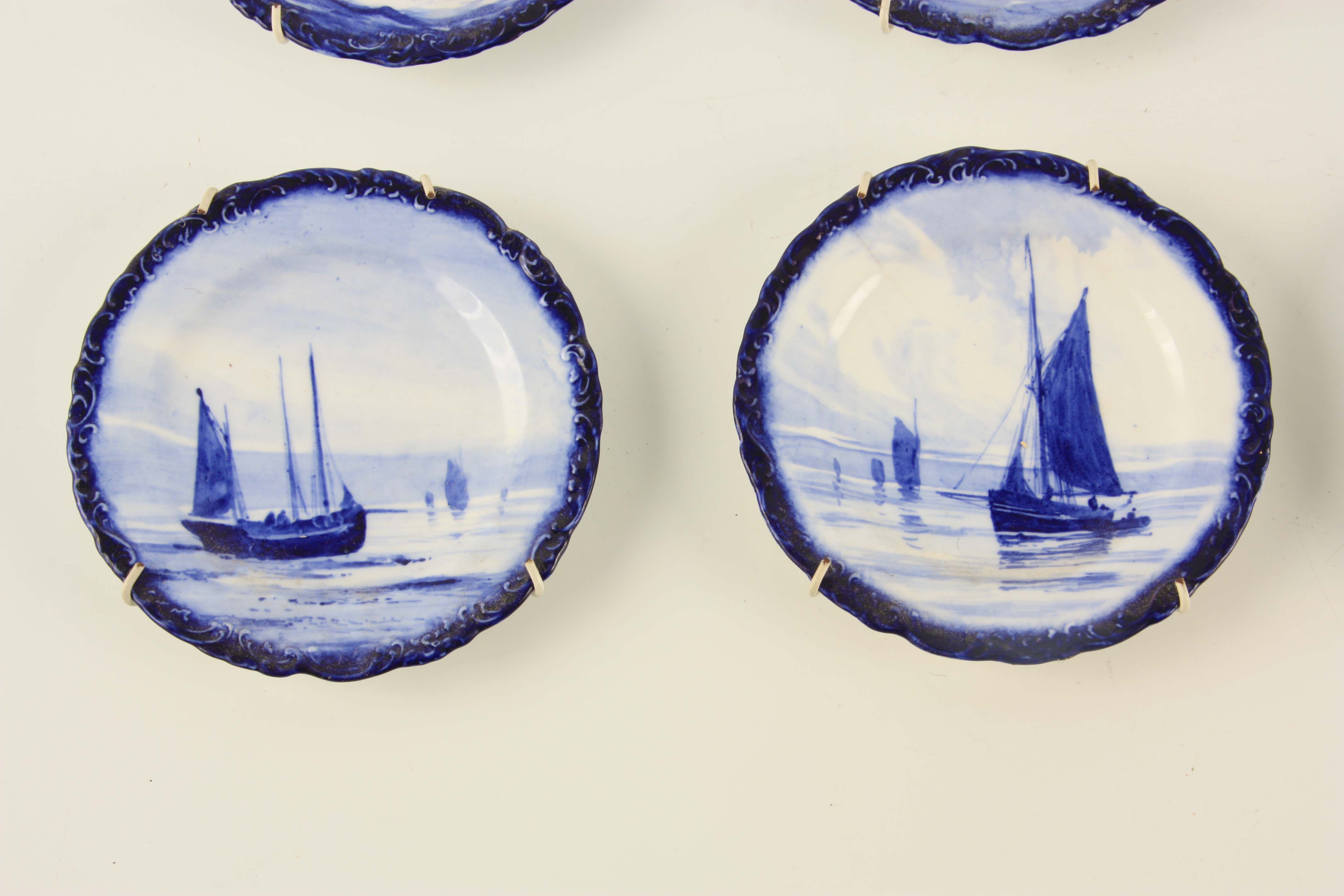 A SET OF EIGHT ROYAL CROWN DERBY SMALL HANGING PLATES painted with differing sailboats on a blue - Image 6 of 9