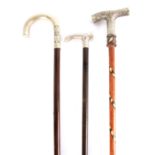 THREE 19TH CENTURY SILVER HANDLED WALKING STICKS with floral leaf work decoration 94cm overall and