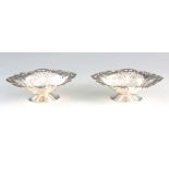 A PAIR OF LATE 20TH CENTURY SILVER EMBOSSED BONBON DISHES with shelled bodies and pedestal bases, by