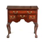 A GEORGE III MAHOGANY LOWBOY with moulded top having inset corners above four drawers fitted with