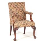 A GEORGE III MAHOGANY ARMCHAIR with upholstered back and sweeping open arms; standing on cabriole