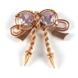 A 14CT GOLD AND POSSIBLY PINK SPINEL BROOCH of ribbon design with twisted chain drops and large pale