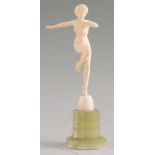 AN ART DECO CARVED IVORY FIGURE modelled as a naked lady dancer mounted on an octagonal onyx base