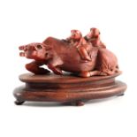 A 19TH CENTURY CARVED WOOD WATER BUFFALO with figures, on a hardwood base, 12cm wide.