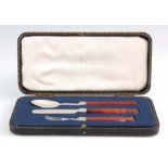 A VICTORIAN CASED THREE-PIECE SILVER AND AGATE CHILD'S CUTLERY SET having floral engravings, by