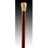 A 19TH CENTURY IVORY HANDLED WALKING STICK having a shaped reeded and feather pommel with amber