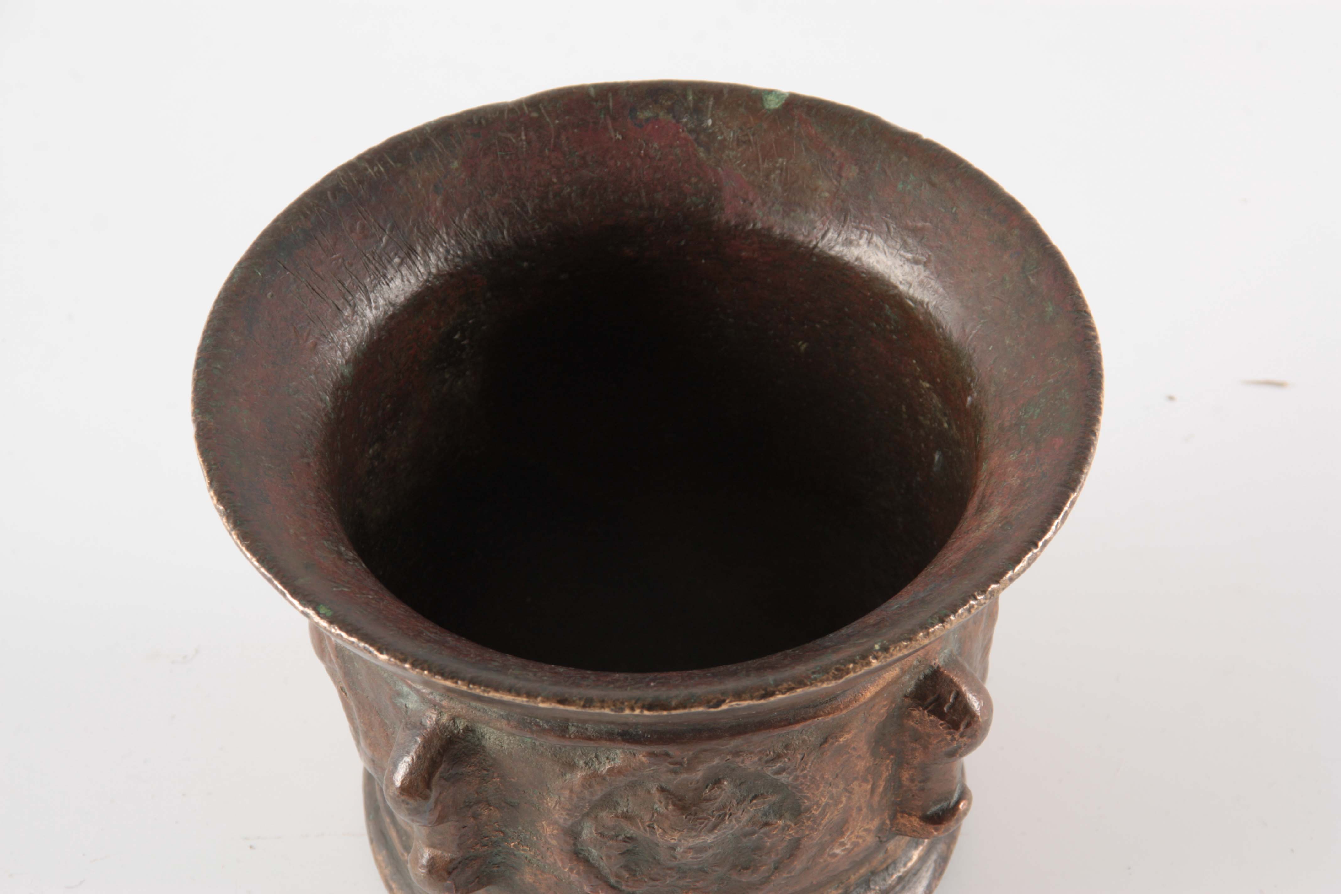 A 17TH CENTURY BRONZE MORTAR with shaped side handles and cast medallions 10cm high 14cm diameter. - Image 3 of 4