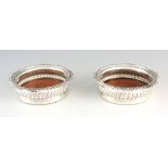 A PAIR OF GEORGE IV CRESTED SILVER WINE COASTERS with shell pattern borders and gadrooned bodies