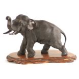 A JAPANESE MEIJI PERIOD PATINATED BRONZE SCULPTURE modelled as an elephant standing on a carved