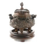 A 19TH CENTURY CHINESE BRONZE CENSER with dome-shaped pierced lid having a torch finial above a