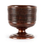 AN EARLY TURNED WALNUT WASSAIL BOWL having a bulbous ringed body; standing on a turned flared foot