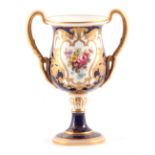 R BARRATT, A ROYAL CROWN DERBY ROYAL BLUE AND JEWELLED GILT TWO HANDLED PEDESTAL CABINET VASE finely